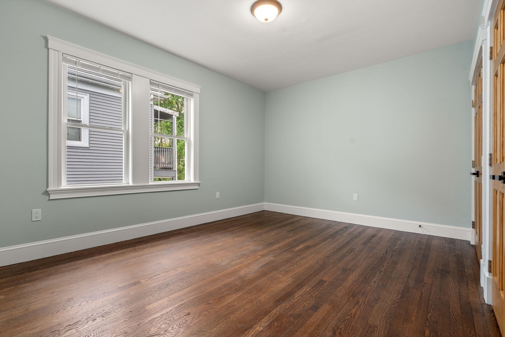 21-23 Westmore Road Boston, MA 02126 - Photo 34 of 42 an empty room with wooden floor and windows
