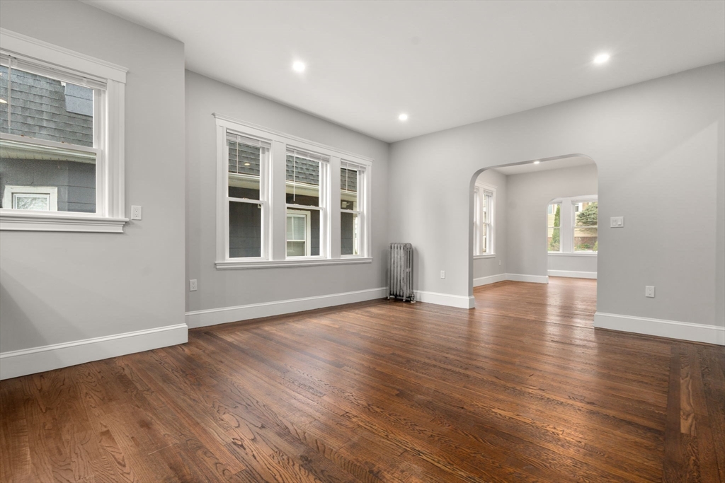 21-23 Westmore Road Boston, MA 02126 - Photo 7 of 42 a view of an empty room with wooden floor and windows
