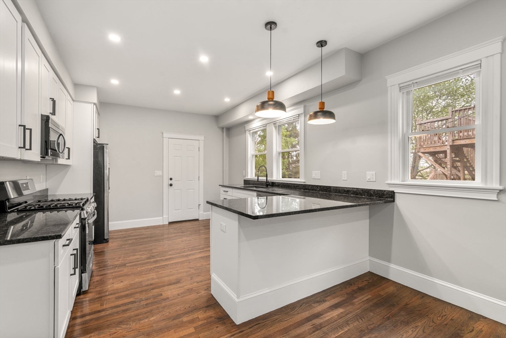 21-23 Westmore Road Boston, MA 02126 - Photo 9 of 42 a kitchen with stainless steel appliances granite countertop a stove a sink and a wooden floors
