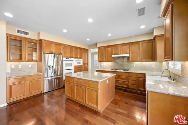 a kitchen with stainless steel appliances granite countertop a stove and a refrigerator