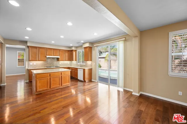 a large kitchen with white cabinets and wooden floor