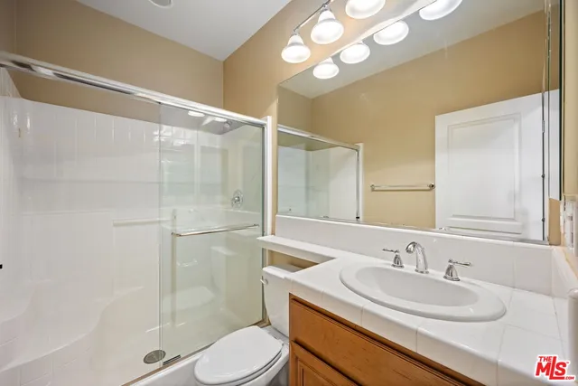 a bathroom with a sink toilet a mirror and shower