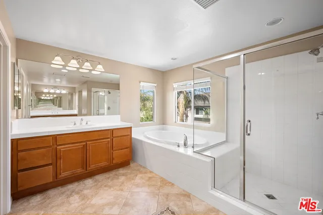 a spacious bathroom with a tub sink and mirror