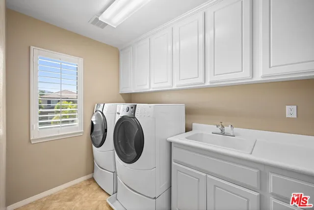 a utility room with sink dryer and washer