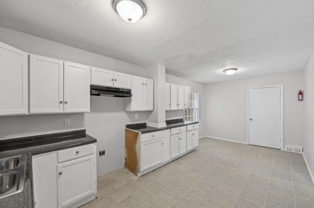 3843 Blue Jay Road Memphis, TN 38116 - Photo 11 of 23 a kitchen with stainless steel appliances granite countertop a stove a sink and white cabinets