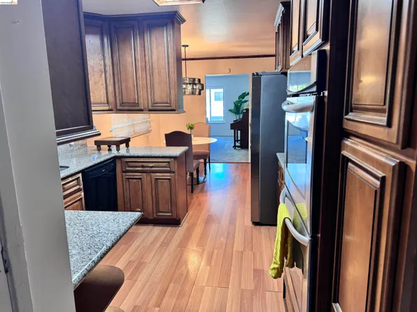 a kitchen with stainless steel appliances granite countertop a refrigerator a sink and wooden cabinets