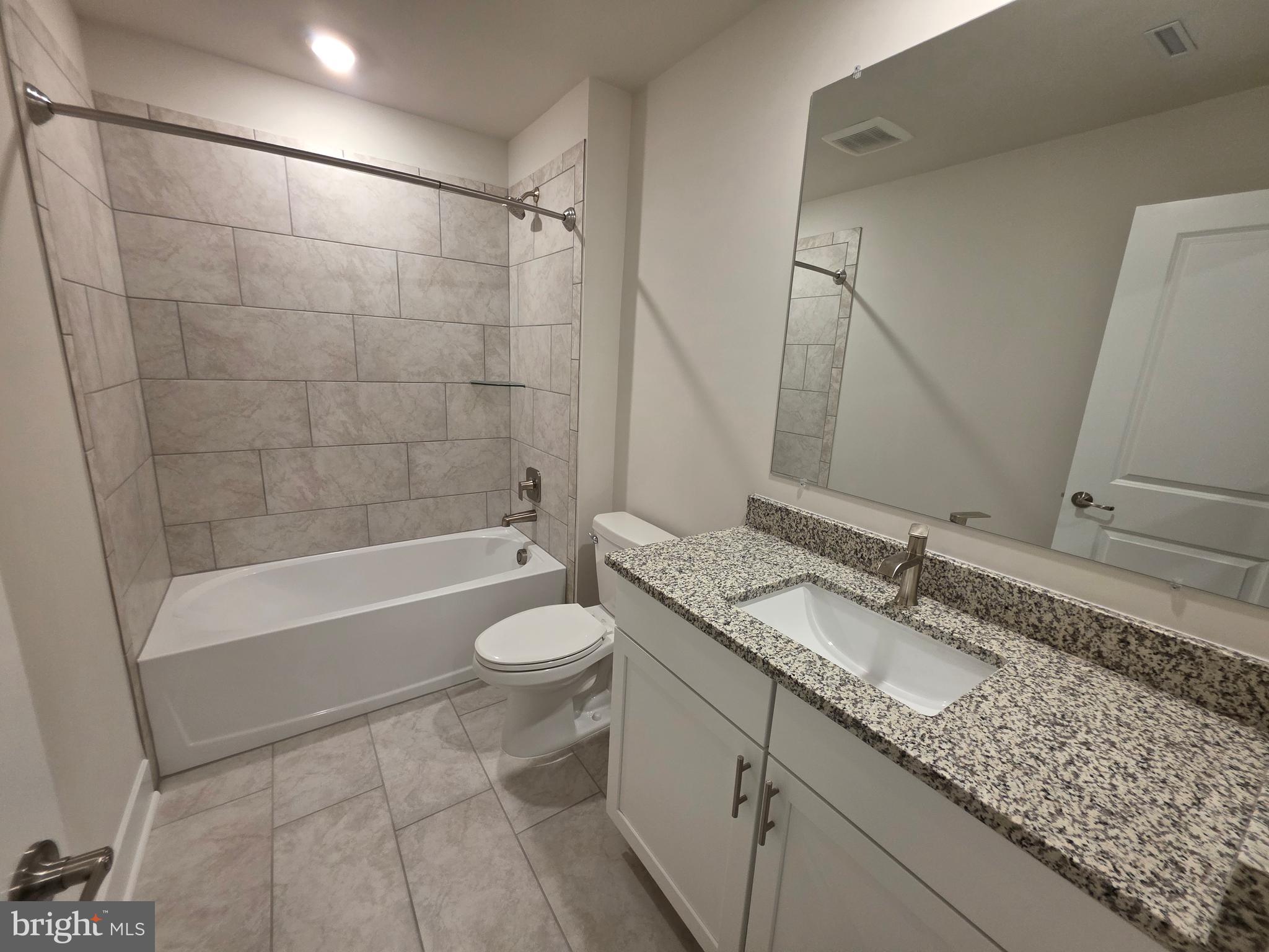 6511 Paddington Street Middle River, MD 21220 - Photo 46 of 46 a bathroom with a granite countertop sink a toilet and bathtub