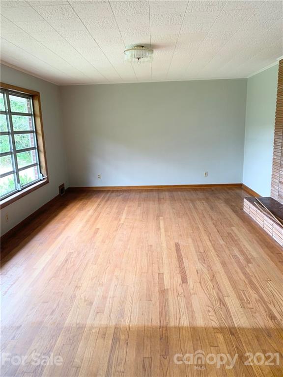 379 South Goforth Road Ferguson, NC 28624 - Photo 4 of 16 an empty room with wooden floor and windows