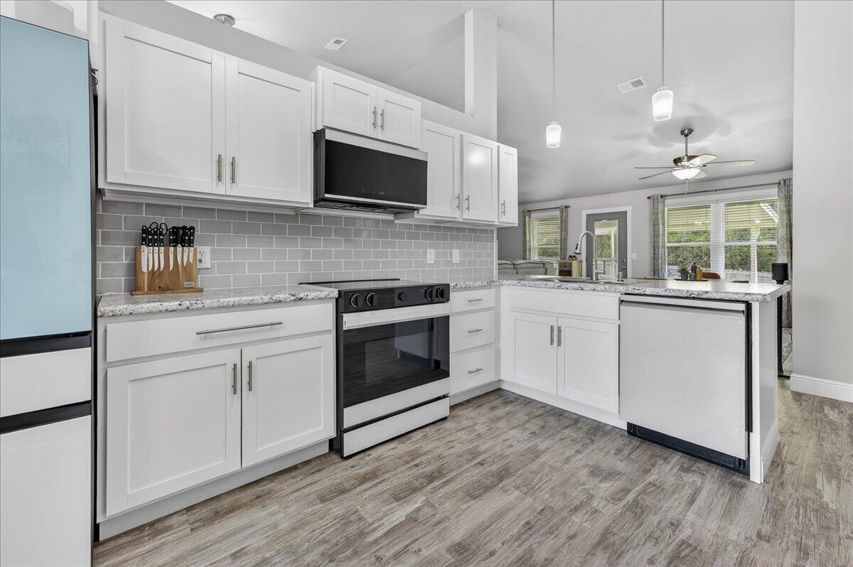 5328 Whitney Court Crestview, FL 32536 - Photo 20 of 48 a kitchen with stainless steel appliances granite countertop a sink a stove a microwave and cabinets