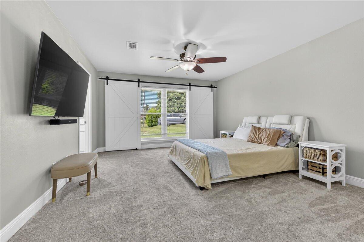 5328 Whitney Court Crestview, FL 32536 - Photo 23 of 48 a spacious bedroom with a bed and a flat screen tv