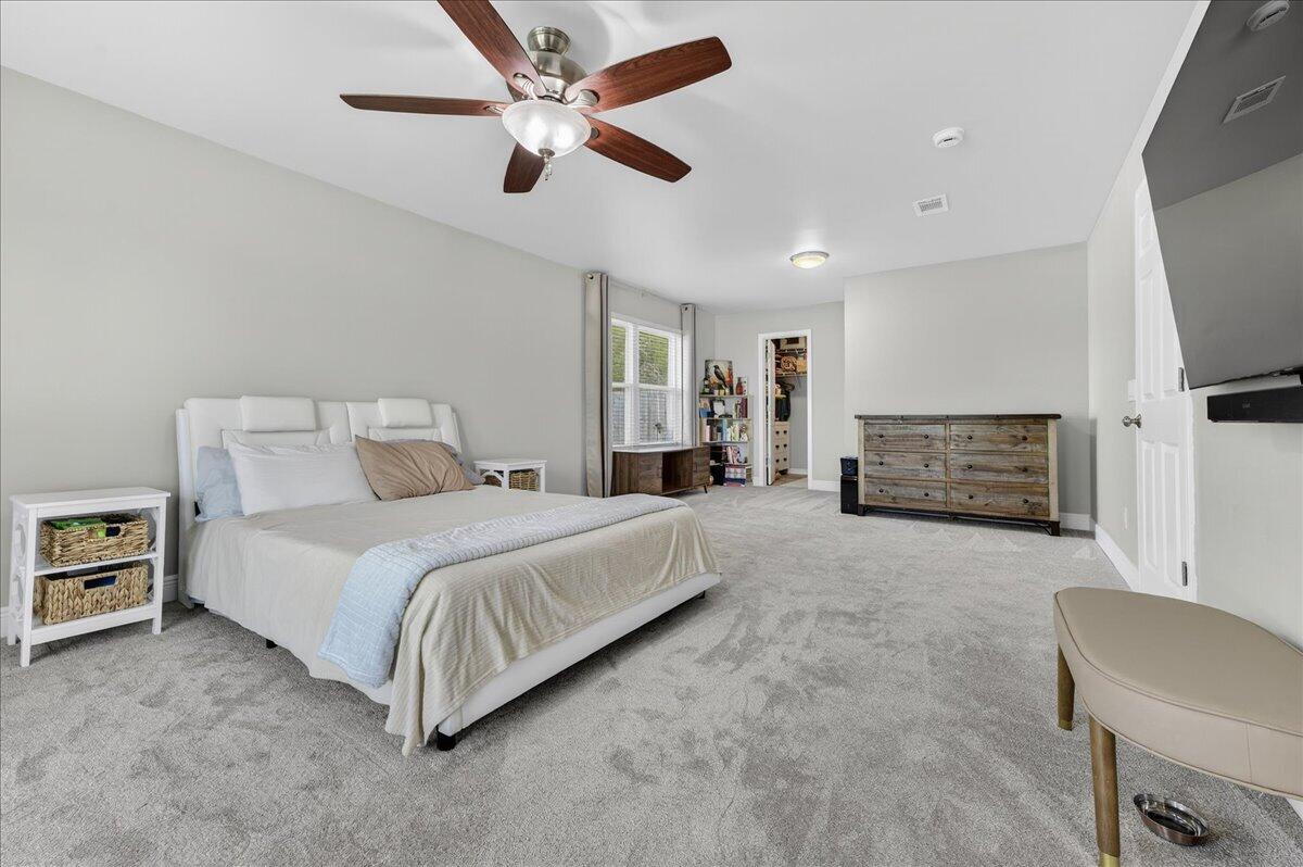 5328 Whitney Court Crestview, FL 32536 - Photo 24 of 48 a spacious bedroom with a bed flat screen tv and couches