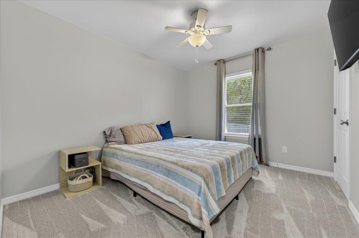 5328 Whitney Court Crestview, FL 32536 - Photo 32 of 48 a bedroom with a bed a chandelier and a flat tv screen