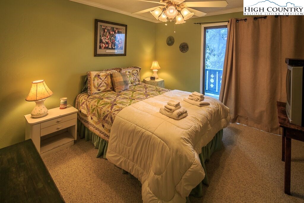 105 North Pinnacle Ridge Road, Unit MNC I # 7 Beech Mountain, NC 28604 - Photo 13 of 39 a bedroom with a bed and a chandelier