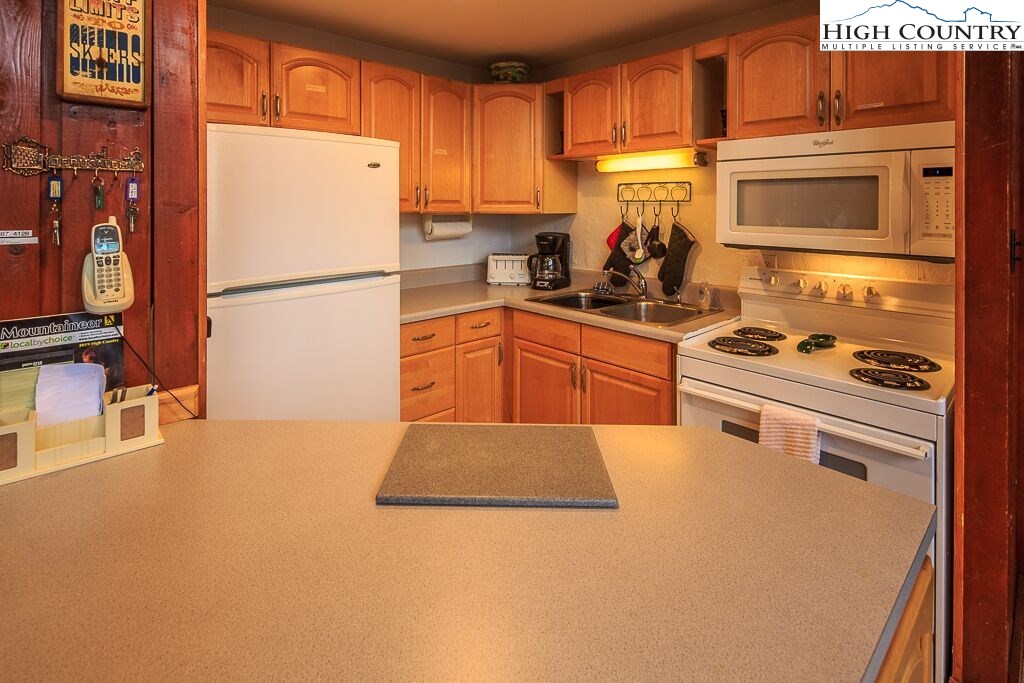 105 North Pinnacle Ridge Road, Unit MNC I # 7 Beech Mountain, NC 28604 - Photo 22 of 39 a kitchen with stainless steel appliances granite countertop a refrigerator stove a sink dishwasher and a microwave