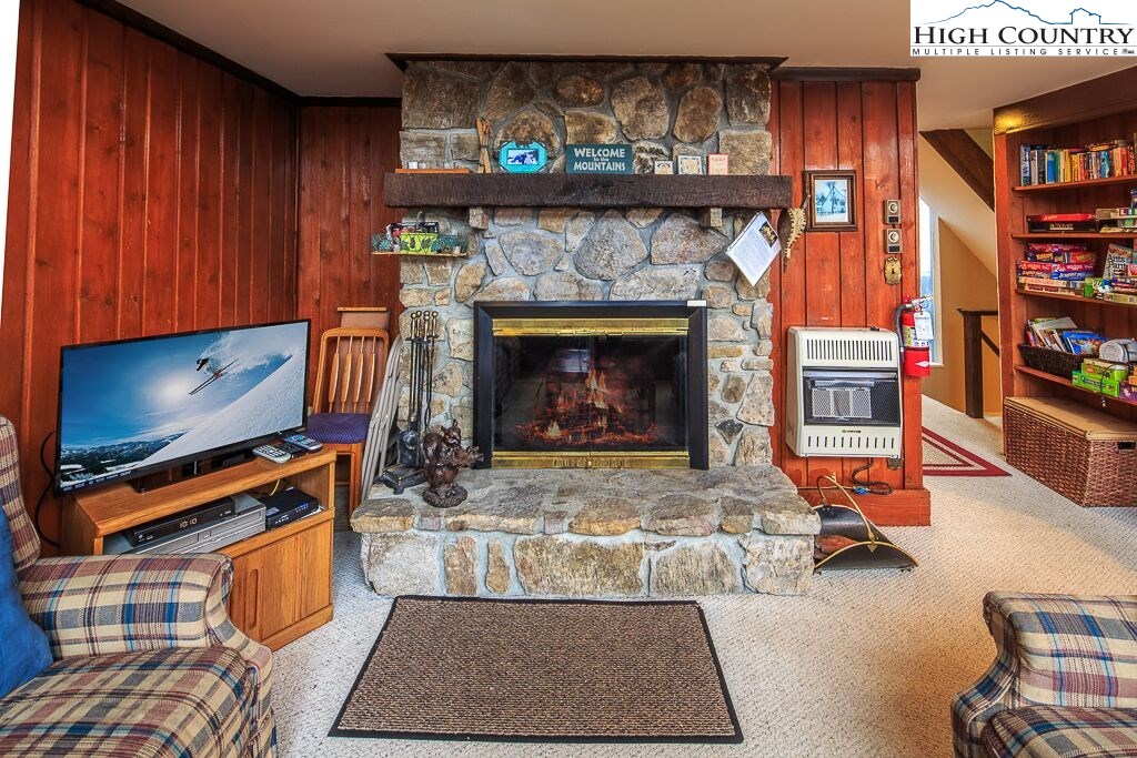 105 North Pinnacle Ridge Road, Unit MNC I # 7 Beech Mountain, NC 28604 - Photo 9 of 39 a living room with furniture a flat screen tv and a fireplace