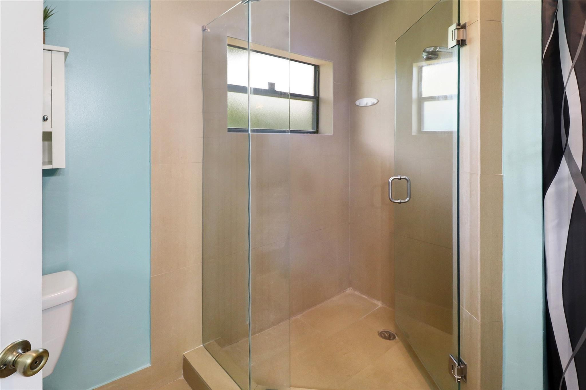 231 Southeast 9th Street Dania Beach, FL 33004 - Photo 22 of 27 a bathroom with a glass shower door