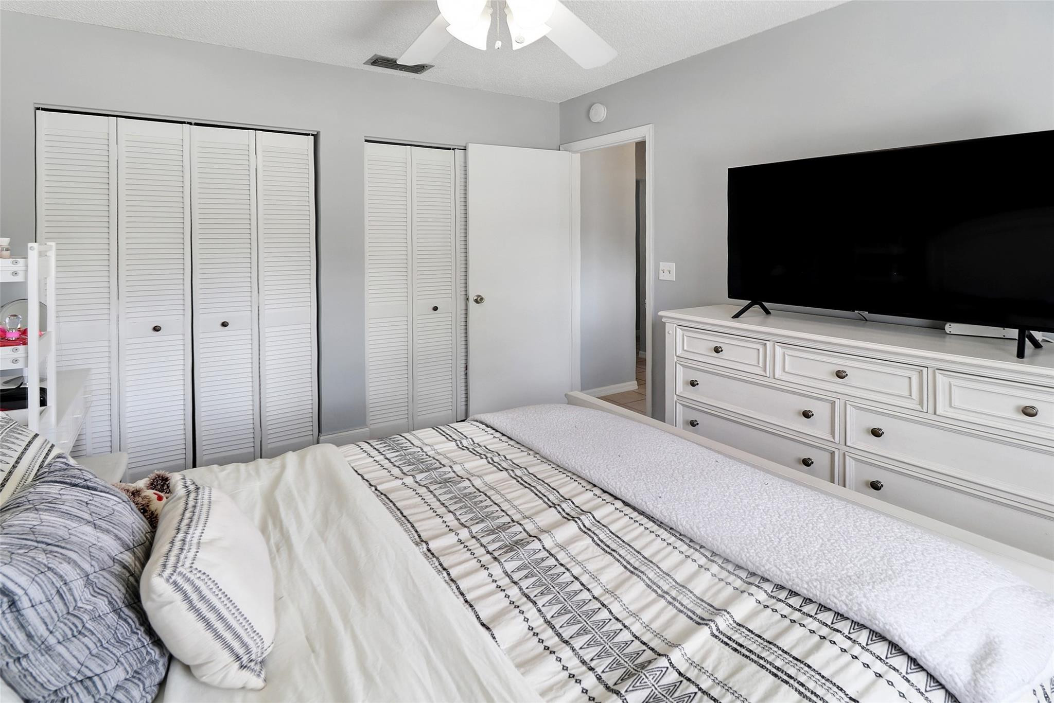 231 Southeast 9th Street Dania Beach, FL 33004 - Photo 23 of 27 a bedroom with a bed a flat screen tv and a chandelier