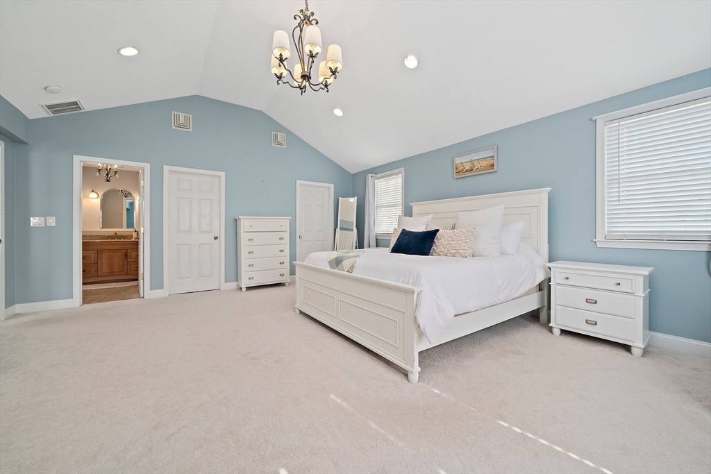 54 Birchcroft Road Canton, MA 02021 - Photo 25 of 37 a spacious bedroom with a bed and a chandelier