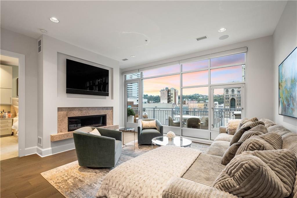 301 Fifth Avenue, Unit 720 Pittsburgh, PA 15222 - Photo 12 of 49 a living room with furniture a fireplace and a flat screen tv