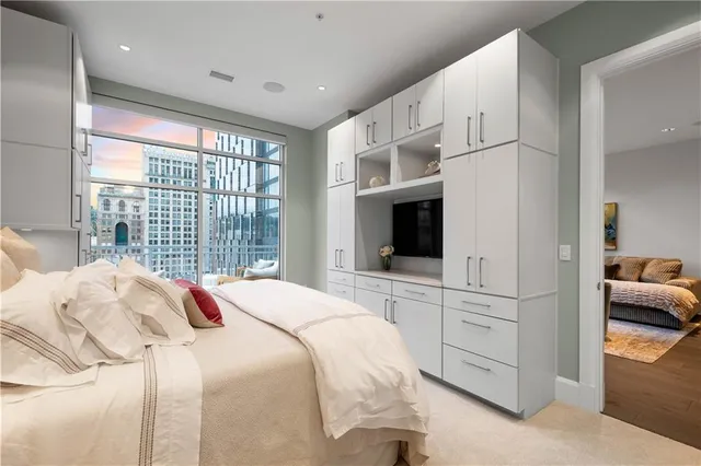 a bedroom with a bed a flat screen tv and a large window