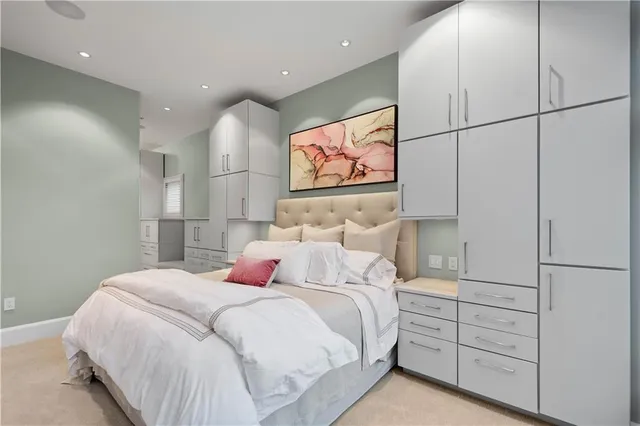 a bedroom with a bed a painting on the wall and a window