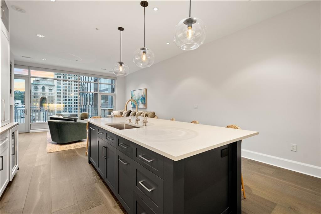 301 Fifth Avenue, Unit 720 Pittsburgh, PA 15222 - Photo 5 of 49 a kitchen with a stove a sink dishwasher a kitchen island with wooden cabinets and floor
