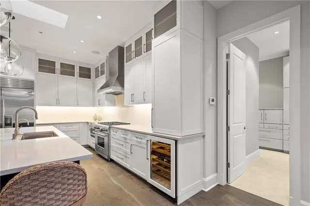 a kitchen with stainless steel appliances granite countertop a sink and a stove with white countertops