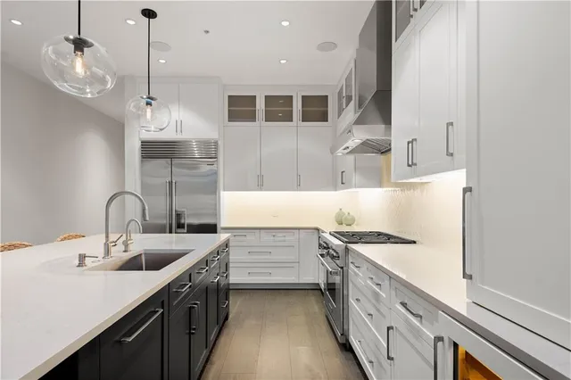 a kitchen with stainless steel appliances a sink stove and cabinets