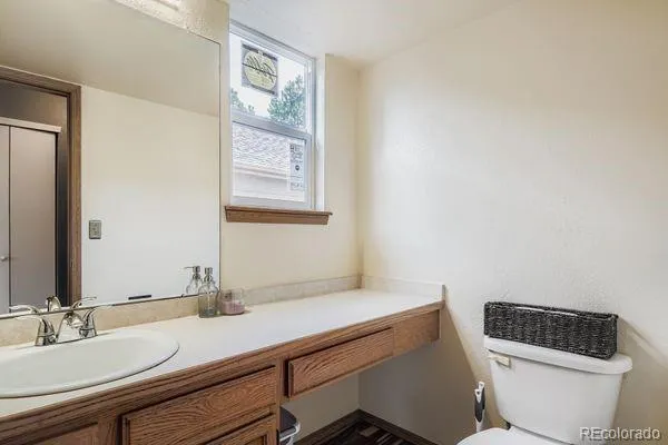 a bathroom with a toilet a sink and mirror