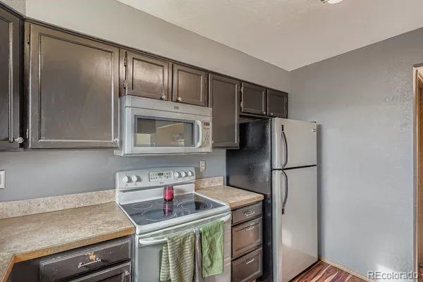 a kitchen with a refrigerator sink and cabinets