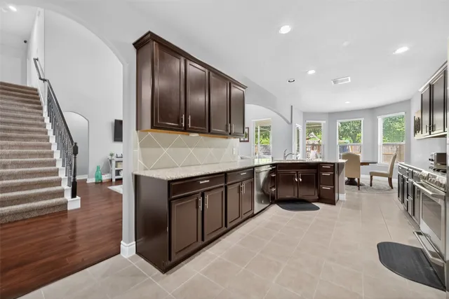 a kitchen with granite countertop cabinets a sink and a stove