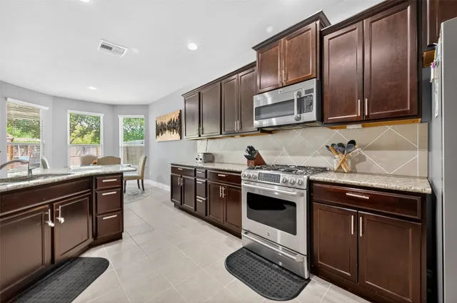 a kitchen with stainless steel appliances granite countertop a stove and a sink