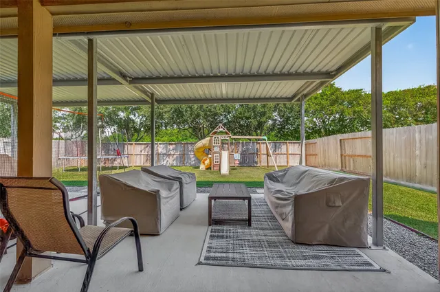 a view of a patio with table and chairs potted plants with wooden floor and fence