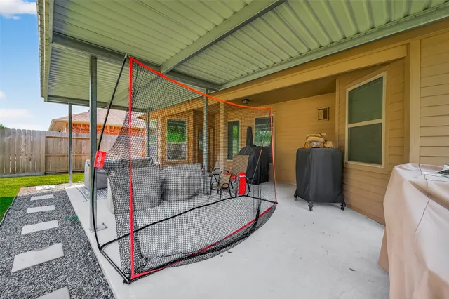 a view of a patio with table and chairs under an umbrella