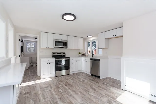 a kitchen with a refrigerator stove and white cabinets