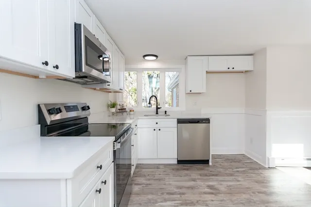 a kitchen with a sink a stove and cabinets