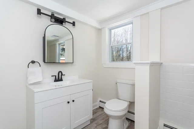 a bathroom with a toilet sink and mirror