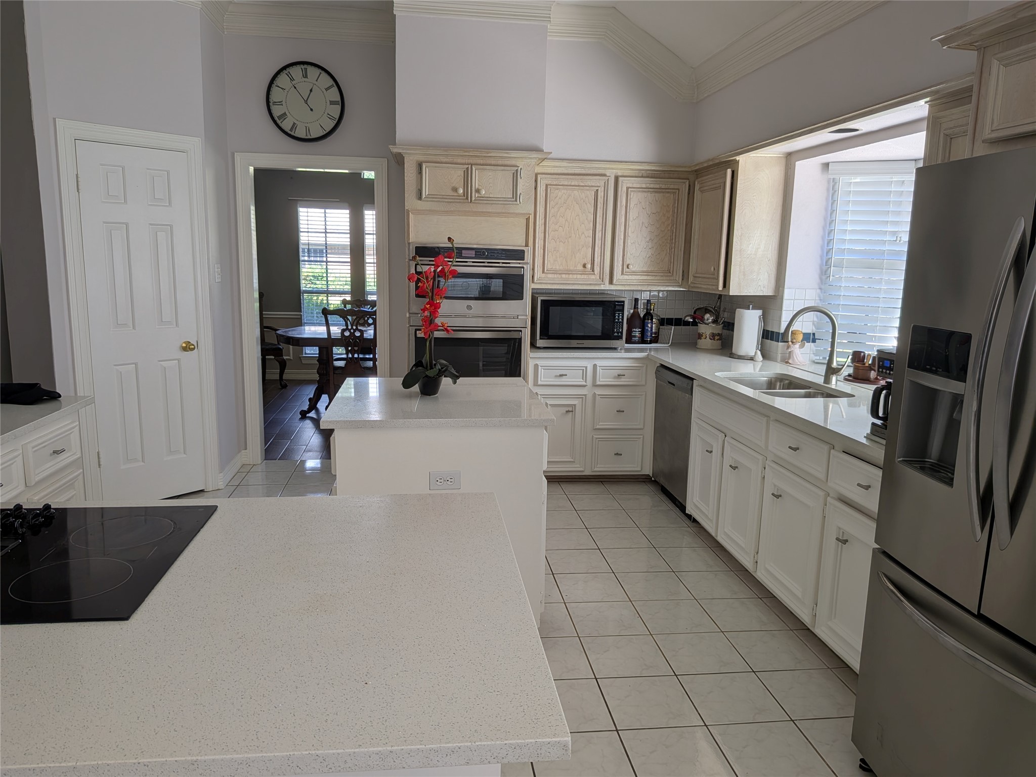 13107 Walnut Lake Road Houston, TX 77065 - Photo 7 of 23 a large white kitchen with a large window a sink and stainless steel appliances