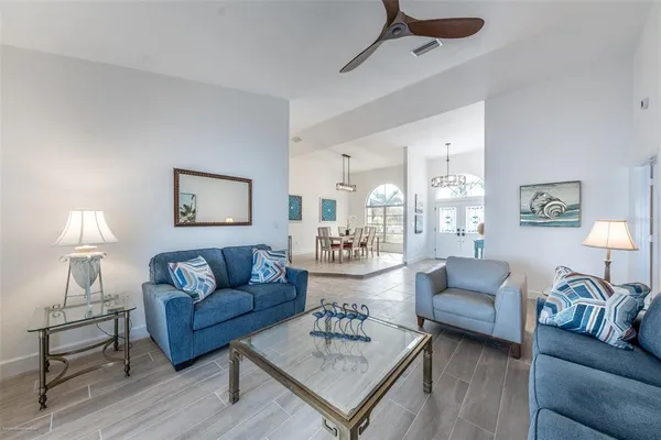 a bedroom with a bed a table and a large window with wooden floor