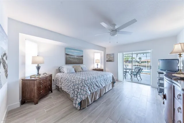 a bedroom with a bed and large windows