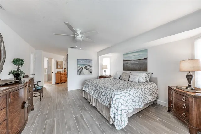 a bedroom with a bed a mirror on dresser and a chandelier