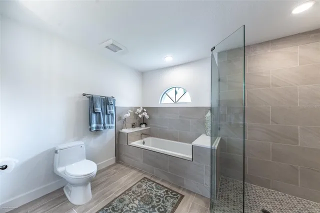 a spacious bathroom with a granite countertop sink a toilet and a mirror