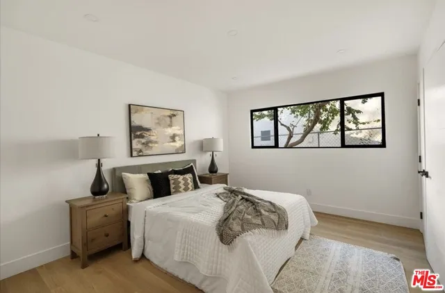 a bedroom with a bed and a painting on the wall