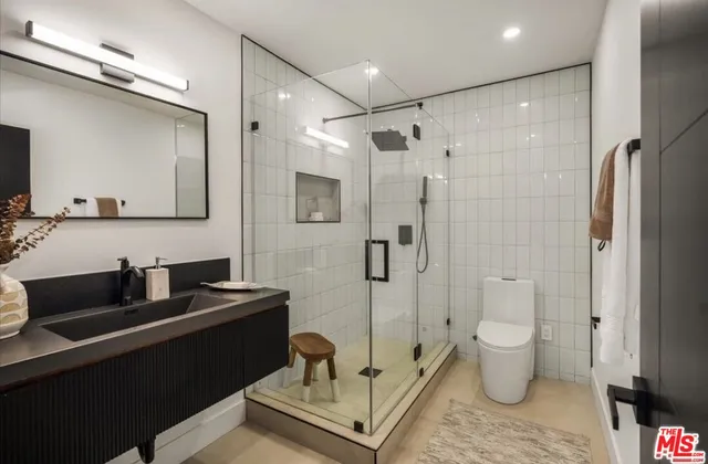 a bathroom with a double vanity sink toilet and shower