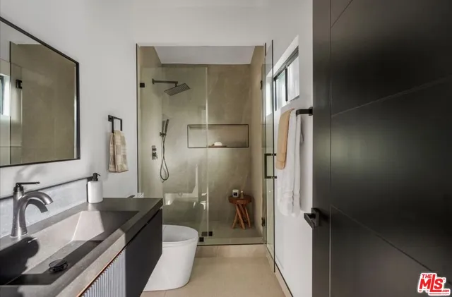 a bathroom with a double vanity sink a mirror and a shower