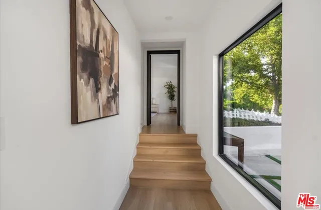 a view of staircase with lots of frames on wall and a large window