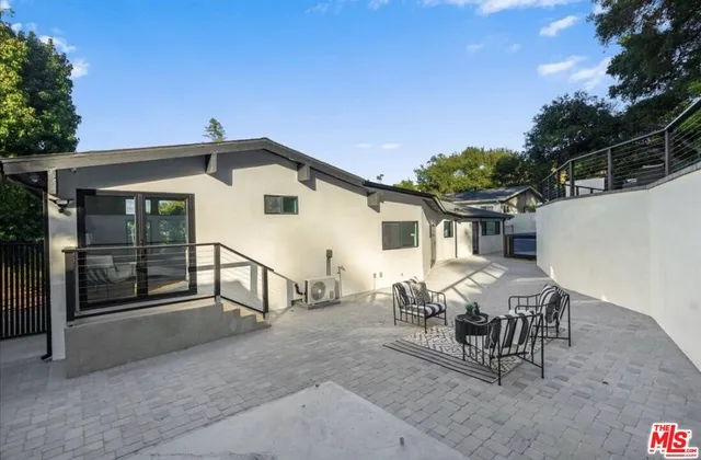 a view of a house with backyard and sitting area