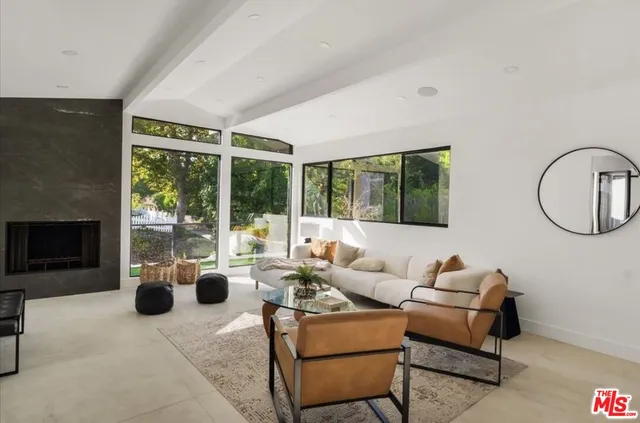 a living room with furniture a fireplace and a floor to ceiling window