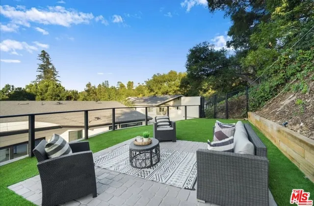a view of a deck with couches table and chairs and potted plants