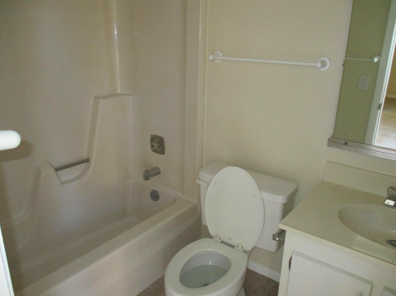 825 Center Street, Unit 3C Jupiter, FL 33458 - Photo 5 of 10 a white toilet sitting next to a bath tub